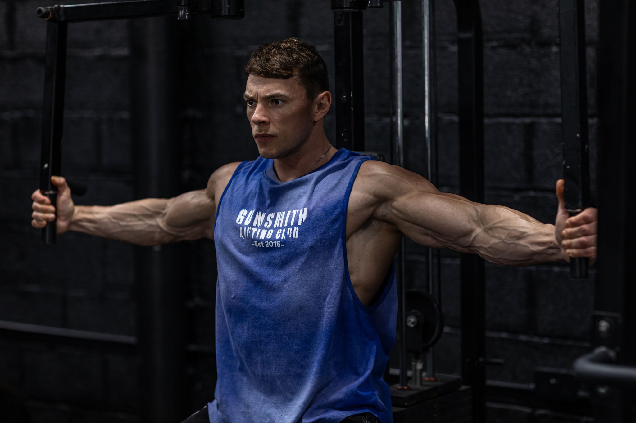 Athlete in the gym wearing the Oversized acid wash gym vest in blue