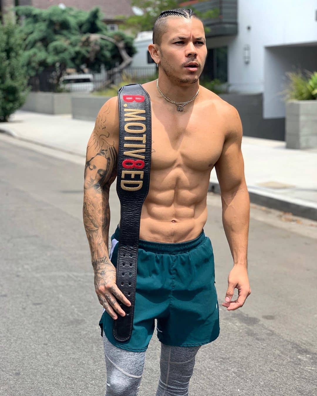 Athlete posing with his bespoke olympic weightlifting belt over shoulder